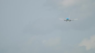 Long shot of a passenger plane approaching to land, front view. Airplane in the sky. Jet civil airliner flying