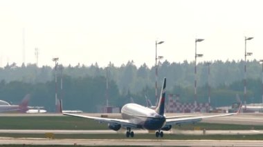 MOSCOW, RUSSIAN FEDERATION - JULY 30, 2021: Aircraft of Aeroflot landing and touchdown, braking at Sheremetyevo airport. Airliner arrival, rear view