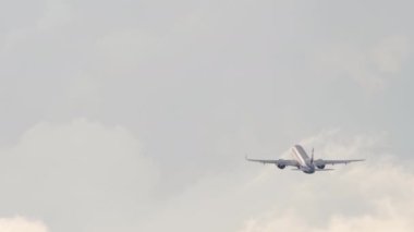 Jet passenger plane flies at dawn or sunset, rear view. Airplane takeoff. Airliner climb after departure. Tourism and travel concept
