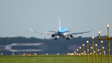 AMSTERDAM, THE NETHERLANDS - JULY 27, 2017: Footage of super slow motion plane KLM Airlines landing at Schiphol airport, rear view. Runway and landing light