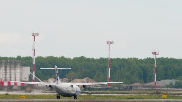 ロシア連邦のノヴォシビルスク 2022年7月15日 Utair航空機のターボプロップがトルマチェヴォ空港で高速化され離陸し サイドビュー — ストック動画