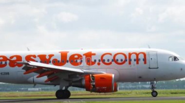 AMSTERDAM, THE NETHERLANDS - JULY 26, 2017: Airbus A319-111, G-EZBB of EasyJet arriving at Schiphol Airport. Airplane braking on the runway, medium shot. Tourism and travel concept