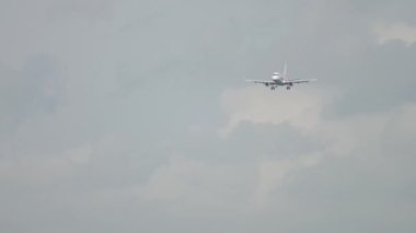 Slow motion footage of jet plane landing. Long shot of an unrecognizable aircraft approaching, descending. Tourism and travel concept
