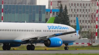 NOVOSIBIRSK, RUSSIAN FEDERATION - JULY 15, 2022: Passenger jet plane Boeing 737 of Pobeda Air takeoff, departure, rear view. Tourism and travel concept