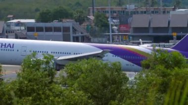 PHUKET, THAILAND - NOVEMBER 28, 2019: Widebody plane of Thai Airways landing at Phuket airport. Airplane touching the runway. Tourism and travel concept