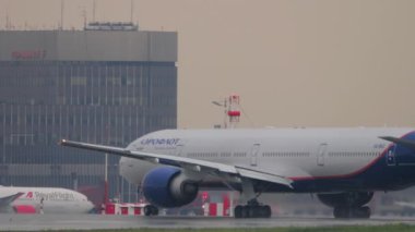 MOSCOW, RUSSIAN FEDERATION - JULY 29, 2021: Boeing 777, VQ-BUC of Aeroflot departure at Sheremetyevo airport SVO. Passenger plane speed up before takeoff. Spray, aircraft landing gear, rain