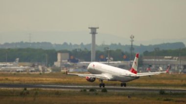 FRANKFURT AM MAIN, GERMANY - JULY 20, 2017: Passenger plane of Austrian Airlines landing at Frankfurt Airport. Jet plane braking. Aircraft arriving. Tourism and travel concept