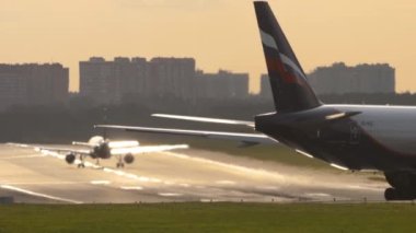 MOSCOW, RUSSIAN FEDERATION - SEPTEMBER 12, 2020: Boeing 777, VQ-BQC of Aeroflot rides on taxiway at Sheremetyevo airport. Airfield at sunset. Airplane takeoff in the background