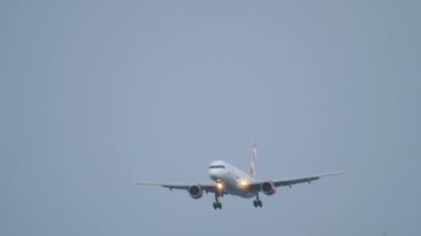 PHUKET, THAILAND - NOVEMBER 28, 2019: Front view of Boeing 757 of Sunday Airlines landing at Phuket Airport. Airliner arrival, flies past trees. Tourism and travel concept