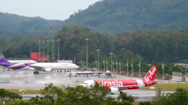 PHUKET, THAILAND - DECEMBER 02, 2016: Low Cost Airbus A320 of AirAsia departure at Phuket Airport. Rainy day, wet airfield. Tourism and travel concept
