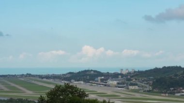 Aircraft landing, takeoff and taxiing to the terminal, timelapse. Cinematic footage from airport traffic. Clouds pile up over the sea, background