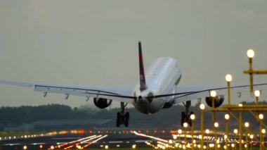 AMSTERDAM, THE NETHERLANDS - JULY 28, 2017: Cinematic footage of a Delta Airlines plane landing and braking. Landing lights illuminate the runway. Tourism and travel concept