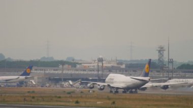 FRANKFURT AM MAIN, GERMANY - JULY 20, 2017: Boeing 747 Lufthansa taking off in a downpour at Frankfurt Airport. Widebody plane departure