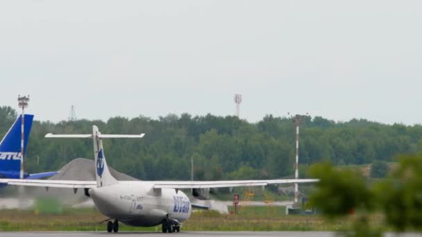 ロシア連邦のノヴォシビルスク発 2022年7月15日 Utair航空機のターボプロップが高速化し トルマチェヴォ空港 リアビューで離陸 — ストック動画
