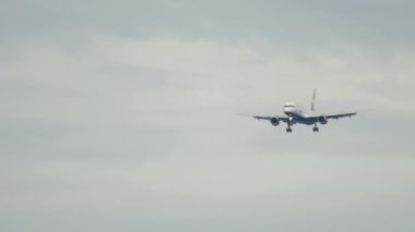 Long shot of an unrecognizable passenger plane approaching landing