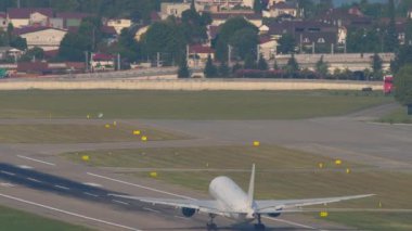 Widebody passenger airplane climb after takeoff, fly away, long shot. Airliner in the blue sky. Plane departure