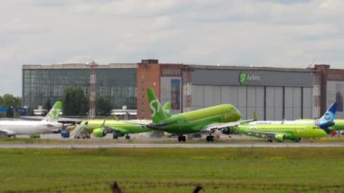 NOVOSIBIRSK, RUSSIAN FEDERATION - JULY 15, 2022: Embraer E170SU, RA-02869 of S7 Airlines landing and braking, slow motion. Footage of a passenger jet plane arriving, side view