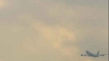 Freight carrier fly away, rear view long shot. Four-engine double-deck airliner departure, takeoff