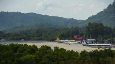 PHUKET, THAILAND - DECEMBER 05, 2016: Timelapse. Passenger airplane at Phuket Airport. Takeoff landing taxiing, panoramic view. Tourism and travel concept