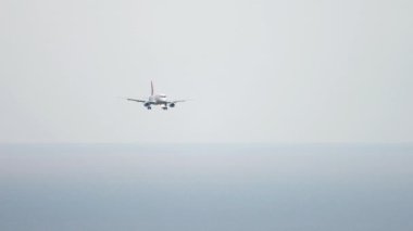 Long shot of civil jet airplane landing at Sochi International Airport. Tourism and travel concept