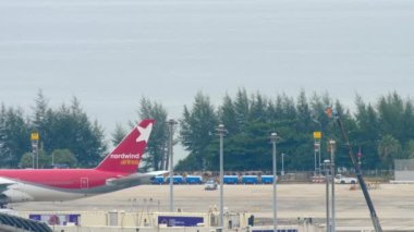 PHUKET, THAILAND - NOVEMBER 28, 2017: Widebody plane of Nordwind taxiing at Phuket airport. Boeing 777 tail, side view. Tourism and travel concept