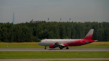 SAINT PETERSBURG, RUSSIA - JULY 26, 2022: Passenger plane of Rossiya braking after landing at Pulkovo airport, side view long shot. Tourism and travel