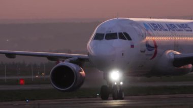 KAZAN, RUSSIA - AUGUST 05, 2022: Civil plane of Ural Airlines taxiing on the runway, sunset or dawn. Airplane on the taxiway at sunrise. Tourism and travel concept