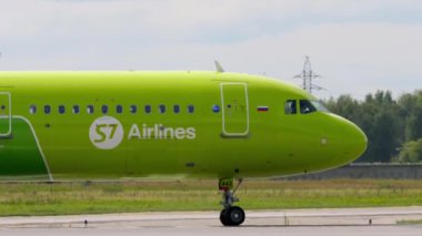 NOVOSIBIRSK, RUSSIAN FEDERATION - JULY 15, 2022: Side view of airplane S7 Airlines taxiing on the runway at Tolmachevo airport. Aircraft on the taxiway. Tourism and travel concept