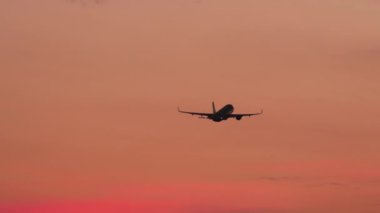 Passenger jet airplane departure, fly away at sunset. Airplane in flight. Tourism and travel concept