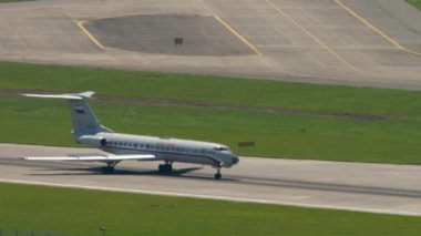 SOCHI, RUSSIA - JULY 28, 2022: Airplane Tupolev Tu-134 of Rossiya - Special Flight Squadron braking after landing at Sochi airport, side view long shot. Tourism and travel concept