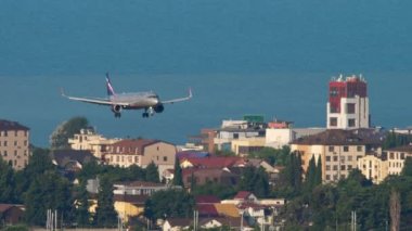 SOCHI, RUSSIA - JULY 28, 2022: Side view of passenger plane Airbus A321 of Aeroflot landing at Sochi airport. Airplane flight, arrival. Tourism and travel concept