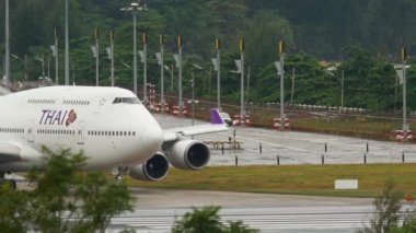 PHUKET, THAILAND - DECEMBER 02, 2016: Footage of widebody airplane Boeing 747 Thai Airways riding on the runway before take off at Phuket airport. Jumbo jet departure. Tourism and travel concept