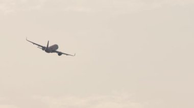 Long shot rear view of a jet passenger plane turning in the sky. Departure plane. Climb after takeoff. Tourism travel concept