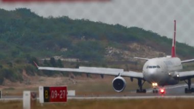 PHUKET, THAILAND - 24 HAZİRAN 2023: Phuket Havaalanı 'na indikten sonra taksiden inen Türk Havayolları A330 Airbus' u. Yolcu uçuşu, çitten geçen havaalanı. Turizm seyahati kavramı