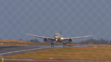 PHUKET, THAILAND - 22 HAZİRAN 2023: Phuket havaalanındaki piste ETIhad uçağı indi ve dokundu. Çitin arkasından bak. Havaalanındaki uçak. Seyahat kavramı