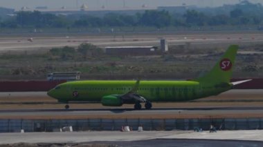 BANGKOK, THAILAND - JANUARY 19, 2023: Airplane of S7 Airlines landing, touching and braking at Suvarnabhumi airport. Passenger flight arriving, side view. Tourism and travel concept