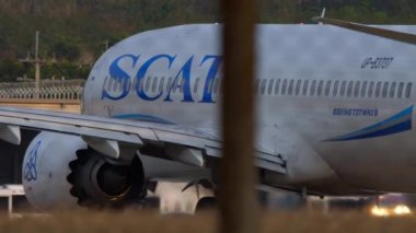 PHUKET, THAILAND - JANUARY 22, 2023: Boeing 737 MAX 8, UP-B3737 of Scat Airlines taxiing at Phuket Airport, medium shot side view through the fence. SCAT Airlines is an airline of Kazakhstan