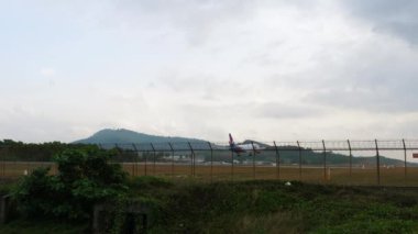 PHUKET, THAILAND - JANUARY 25, 2023: Civil plane Boeing 757, RA-73077 of Azur Air landing at Phuket airport, long shot. Tourism travel concept