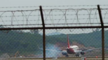 PHUKET, THAILAND - JANUARY 30, 2023: Boeing 737 MAX 8, VT-MXH of SpiceJet braking after landing at Phuket Airport. Flaps up. Reset speed. SpiceJet Indian low cost airline