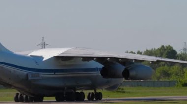 NOVOSIBIRSK, RUSSIAN FEDERATION - JUNY 12, 2022: IL 76 cargo transport aircraft taxiing at Tolmachevo airport, side view, medium shot