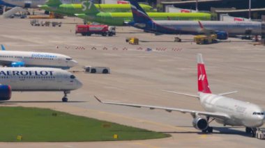 SOCHI, RUSSIA - JULY 29, 2022: Airbus A330 of Nordwind Airlines on the taxiway at Sochi airport. Row of planes at the terminal. Tourism and air travel concept
