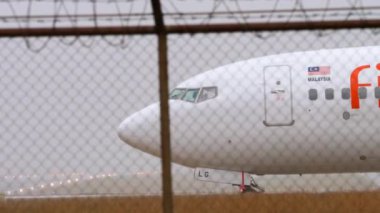 PHUKET, THAILAND - JANUARY 25, 2023: Civil airplane Boeing 737, 9M-MLG of Firefly taxiing to the runway at Phuket Airport, side view. Passenger flight departure