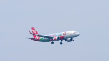 PHUKET, THAILAND - 28 HAZİRAN 2023: AirAsia Sürdürülebilir ASEAN Turizm Livery yolcu uçağı Phuket havaalanına inmeden önce yaklaşıyor. Uçak uçuşları, mavi gökyüzü arkaplanı