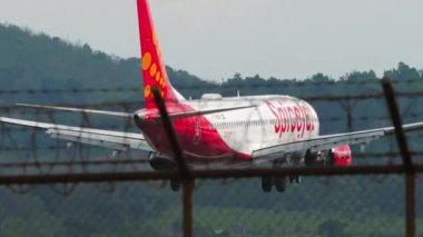PHUKET, THAILAND - JANUARY 30, 2023: Boeing 737 of SpiceJet landing, touching and braking at Phuket Airport. Flaps up. Passenger plane arriving at the airport. Reset speed. SpiceJet Indian low cost