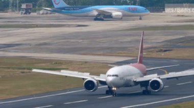 PHUKET, THAILAND - Şubat, 2023: Boeing 777-2Q8ER, RA-73272 Pegas Fly uçağı Phuket havaalanına indikten sonra fren yapıyor. Geniş gövdeli varış. Kanatçıklar yukarı, hız aşağı