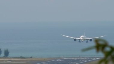 PHUKET, THAILAND - Şubat 03, 2023: Boeing 787, El Al 'in 4X-EDA' ya iniş ve Phuket Havaalanı 'na dokunma ihtimali çok düşük. Uçak geliyor, ön manzara. Flaplar yukarı, hız aşağı. Pist, deniz arkaplanı