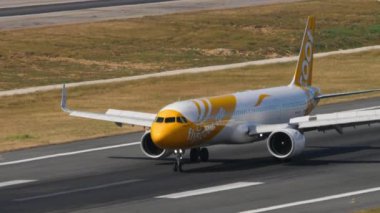 PHUKET, THAILAND - FEBRUARY 07, 2023: Airbus A321-271NX, 9V-NCD of Scoot arriving, braking after landing at Phuket Airport. Airplane on the taxiway, side view. Footage of plane driving. Spotting