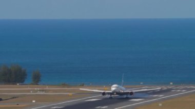 PHUKET, THAILAND - Şubat 2007, 2023: Boeing 767, RA-73078 Azur Havaalanı 'na iniş ve frenleme. Taksiyoldaki uçak, ön manzara. Uçak dokunuşunun görüntüsü. Pist ve deniz arka planı