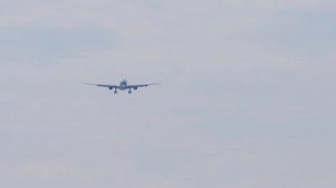 Tanımlanamayan bir jet uçağının iniş için yaklaşma ihtimali çok düşük. Uçak sinekleri, mavi gökyüzü arkaplanı. Uçak silueti iniyor, geniş açılı görüş. Seyahat kavramı