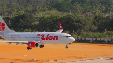 PHUKET, THAILAND - FEBRUARY 08, 2023: Commercial plane Boeing 737, HS-LUZ of Thai Lion landing at Phuket Airport. Aircraft descending, side view. Tourism travel concept